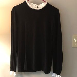 Black sweater with white ruffle trim